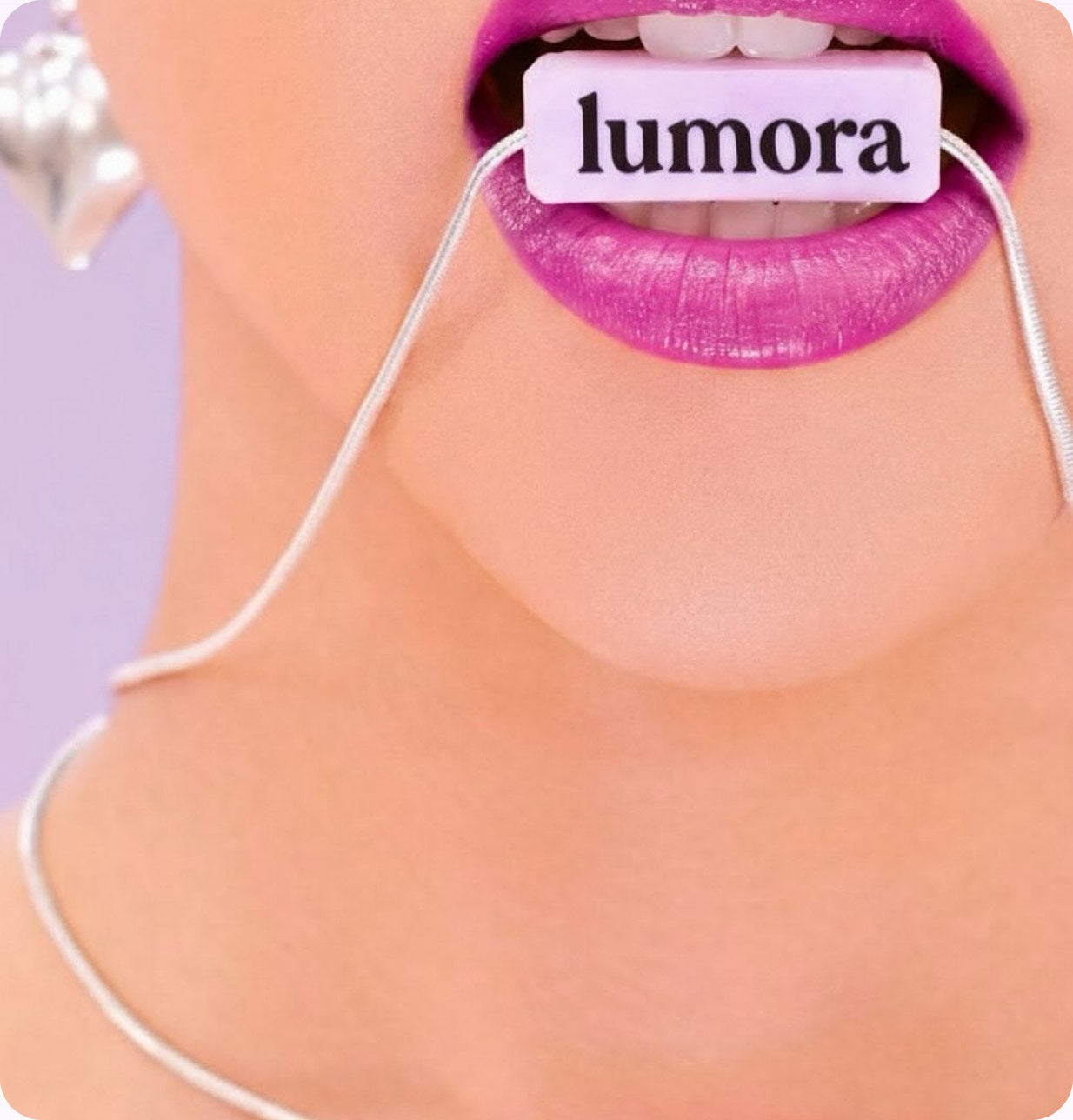 Close-up of a woman's lips holding a Lumora branded floss tag